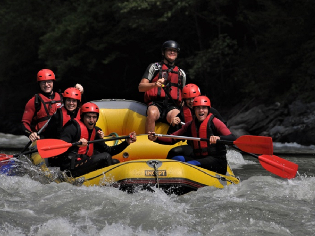 White water rafting near Salzburg and Innsbruck, Austria with a group paddling through river rapids in a guided raft.
