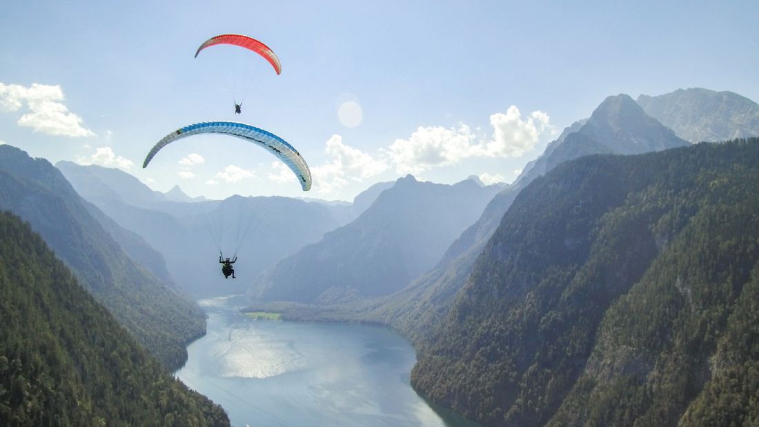 Paragliding near Schönau am Königssee with scenic alpine mountain views over the lake and surrounding valleys in Austria.